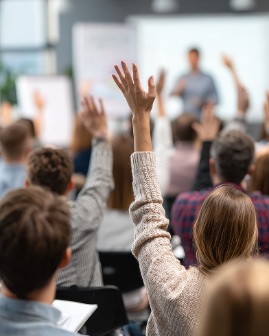 Audience raising hands in classroom